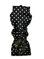 Load image into Gallery viewer, Black polka dot necktie necklace with a decorative brooch on a white background

