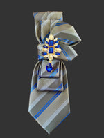 Load image into Gallery viewer, Gray and blue striped tie with decorative brooch on a gray background
