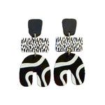 Load image into Gallery viewer, Black and white patterned earrings on a textured cushion with a white background

