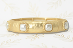Load image into Gallery viewer, A gold bangle bracelet featuring square white pearl inlays set in a beaded border, shown against a white background with gold leafing.
