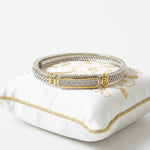 Load image into Gallery viewer, Gold and silver bracelet on a white and gold jewelry pillow 
